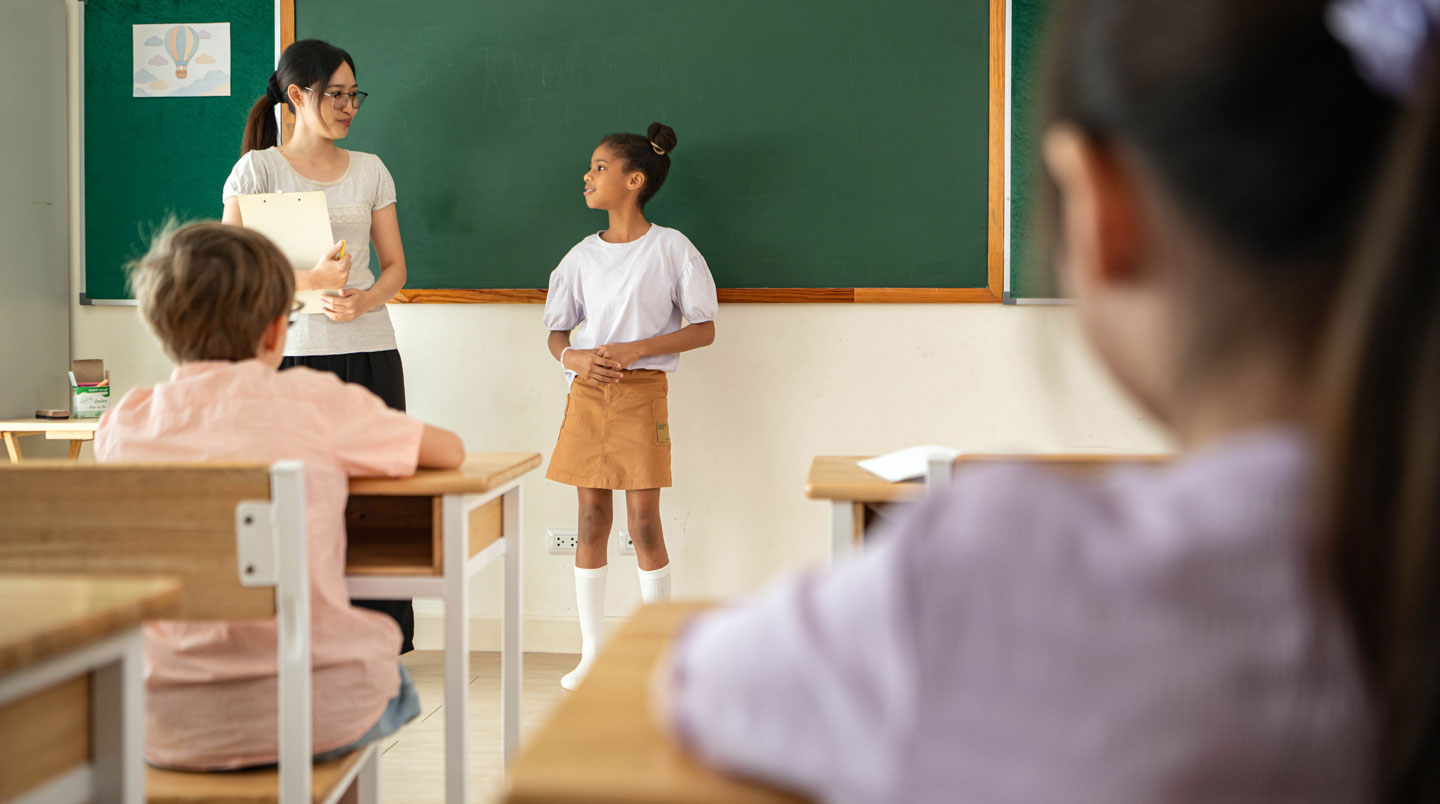 Intérieur d'une salle de classe de lycée australien moderne et vide, avec de grandes fenêtres laissant entrer une lumière naturelle abondante et du mobilier contemporain coloré
